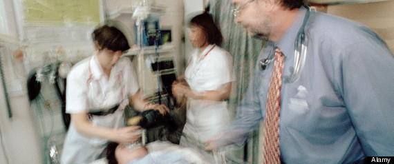 Doctors and nurses attending to a patient in the crash room of an accident and emergency department in a hospital.